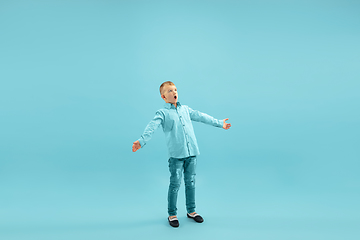 Image showing Childhood and dream about big and famous future. Pretty little boy isolated on blue background