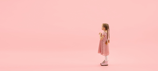 Image showing Childhood and dream about big and famous future. Pretty longhair girl isolated on coral pink background