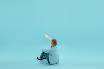 Image showing Childhood and dream about big and famous future. Pretty little boy isolated on blue background