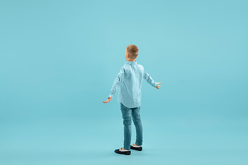 Image showing Childhood and dream about big and famous future. Pretty little boy isolated on blue background