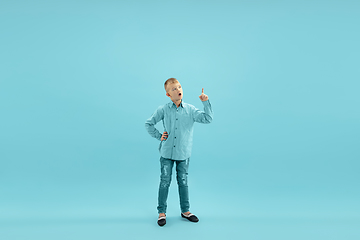 Image showing Childhood and dream about big and famous future. Pretty little boy isolated on blue background