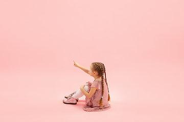 Image showing Childhood and dream about big and famous future. Pretty longhair girl isolated on coral pink background