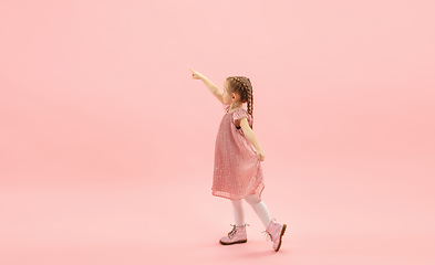 Image showing Childhood and dream about big and famous future. Pretty longhair girl isolated on coral pink background