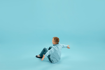 Image showing Childhood and dream about big and famous future. Pretty little boy isolated on blue background