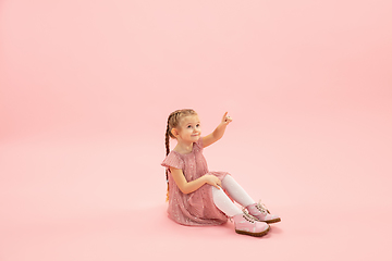 Image showing Childhood and dream about big and famous future. Pretty longhair girl isolated on coral pink background