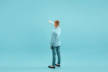 Image showing Childhood and dream about big and famous future. Pretty little boy isolated on blue background