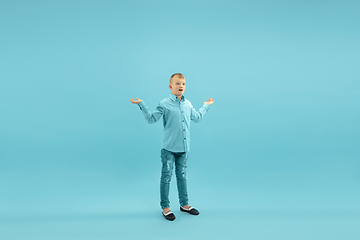 Image showing Childhood and dream about big and famous future. Pretty little boy isolated on blue background