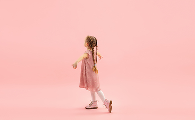 Image showing Childhood and dream about big and famous future. Pretty longhair girl isolated on coral pink background