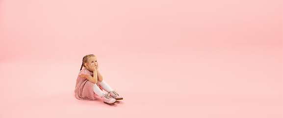 Image showing Childhood and dream about big and famous future. Pretty longhair girl isolated on coral pink background