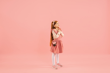 Image showing Childhood and dream about big and famous future. Pretty longhair girl isolated on coral pink background