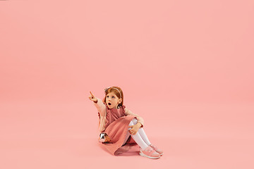 Image showing Childhood and dream about big and famous future. Pretty longhair girl isolated on coral pink background