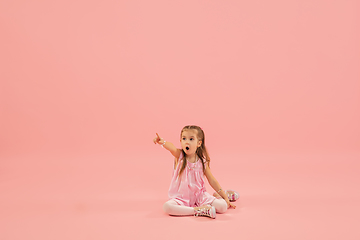 Image showing Childhood and dream about big and famous future. Pretty longhair girl isolated on coral pink background