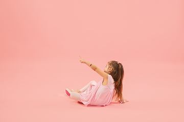 Image showing Childhood and dream about big and famous future. Pretty longhair girl isolated on coral pink background