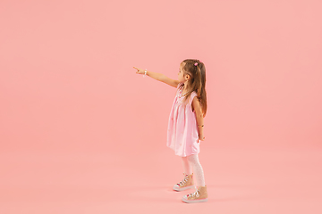 Image showing Childhood and dream about big and famous future. Pretty longhair girl isolated on coral pink background