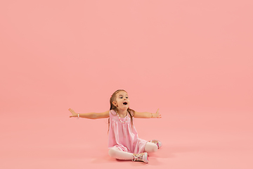 Image showing Childhood and dream about big and famous future. Pretty longhair girl isolated on coral pink background