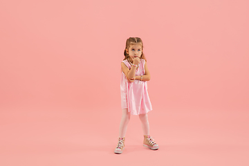 Image showing Childhood and dream about big and famous future. Pretty longhair girl isolated on coral pink background