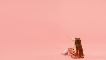 Image showing Childhood and dream about big and famous future. Pretty longhair girl isolated on coral pink background