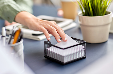 Image showing businesswoman taking note paper at office