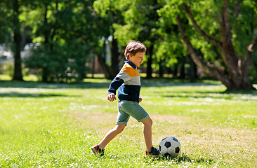 Image showing happy little boy with ball playing soccer at park