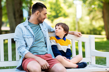 Image showing father with son sitting on park bench and talking