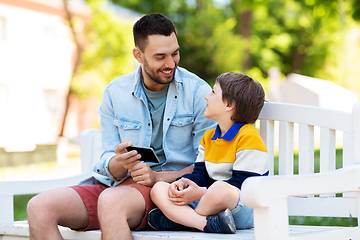 Image showing father and son with smartphone at park