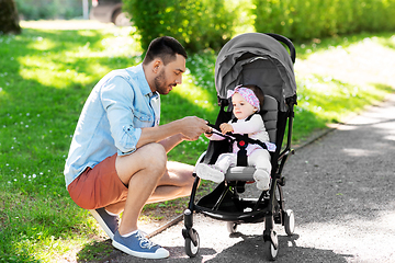 Image showing happy father with child in stroller at summer park