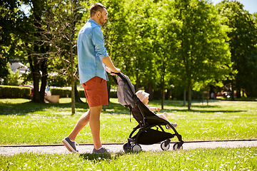 Image showing happy father with child in stroller at summer park