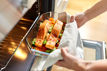 Image showing woman cooking food in oven at home kitchen