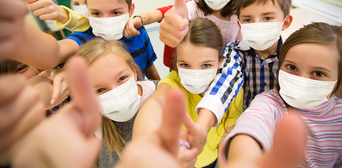 Image showing group of children in masks showing thumbs up