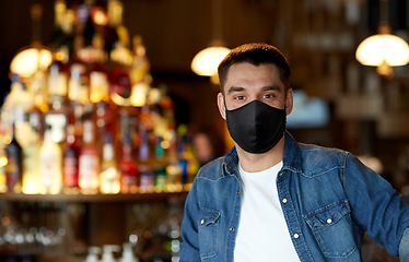 Image showing young man in black reusable mask at bar or pub