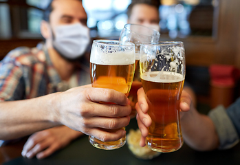 Image showing male friends in masks drinking beer at bar or pub
