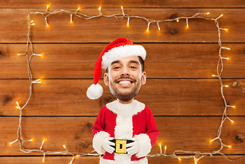 Image showing happy santa over garland on wooden background