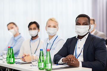 Image showing business people in masks at worldwide conference