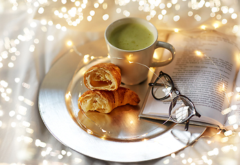 Image showing croissants, matcha tea, book and glasses in bed