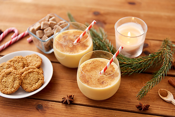 Image showing glasses of eggnog, oatmeal cookies and fir branch