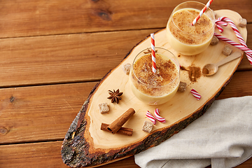 Image showing glasses of eggnog, ingredients and spices on wood