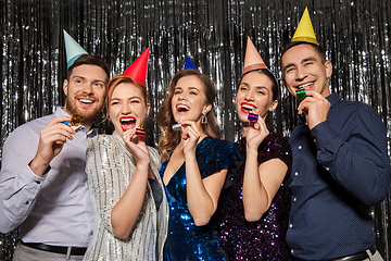 Image showing happy couple with party blowers having fun