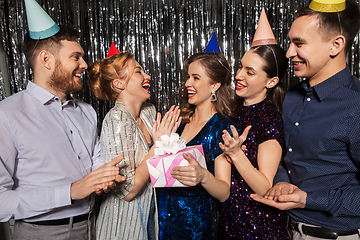 Image showing happy friends in party hats with birthday gift