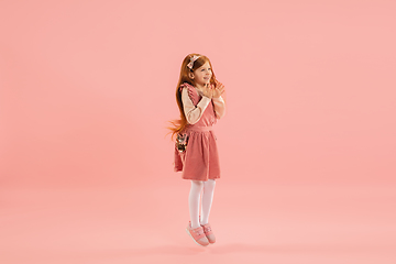 Image showing Childhood and dream about big and famous future. Pretty longhair girl isolated on coral pink background