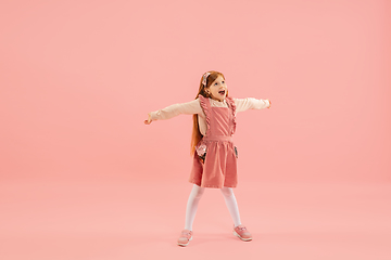 Image showing Childhood and dream about big and famous future. Pretty longhair girl isolated on coral pink background