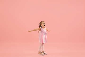 Image showing Childhood and dream about big and famous future. Pretty longhair girl isolated on coral pink background