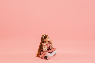 Image showing Childhood and dream about big and famous future. Pretty longhair girl isolated on coral pink background