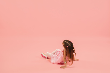 Image showing Childhood and dream about big and famous future. Pretty longhair girl isolated on coral pink background