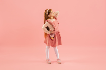 Image showing Childhood and dream about big and famous future. Pretty longhair girl isolated on coral pink background