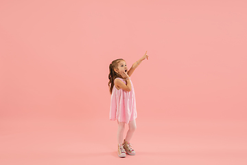 Image showing Childhood and dream about big and famous future. Pretty longhair girl isolated on coral pink background