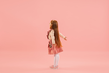 Image showing Childhood and dream about big and famous future. Pretty longhair girl isolated on coral pink background