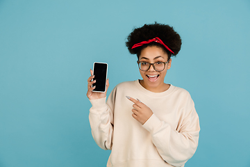 Image showing African-american woman\'s portrait isolated on blue studio background with copyspace