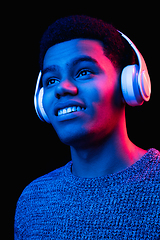 Image showing African-american man\'s portrait isolated on black studio background in multicolored neon light