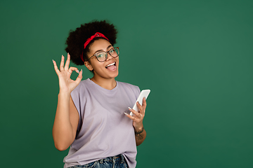 Image showing African-american woman\'s portrait isolated on green studio background with copyspace