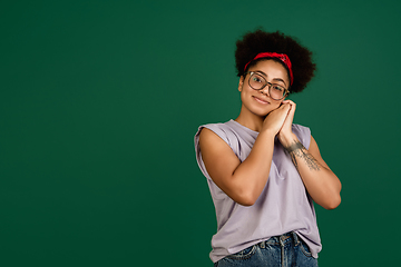 Image showing African-american woman\'s portrait isolated on green studio background with copyspace